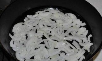 Репчатый лук режем тонкими полукольцами. Обжариваем овощ до мягкости на сковороде с растительным маслом.