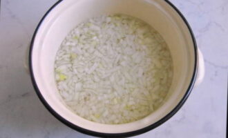 К мясному бульону добавляем промытый рис с измельченным луком и оставляем вариться на маленьком огне до полной готовности риса.