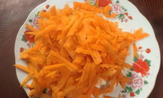 Морковь чистим и натираем на крупной тёрке. На сковороде разогреваем растительное масло и обжариваем на нём морковь с луком до полуготовности.