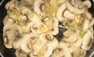 Нагреваем сковороду с растительным маслом. Сперва обжариваем здесь лук, затем добавляем грибы. Солим содержимое и посыпаем специями. Готовим около 15 минут.