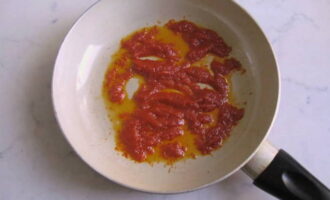 На разогретую с подсолнечным маслом сковородку отправляем томатную пасту, чтобы она слега поджарилась.