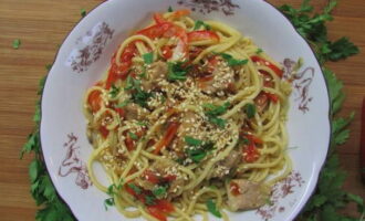 Готовую курицу ВОК с овощами и соусом можно обсыпать кунжутом, а после разложить по тарелкам и подавать к столу.