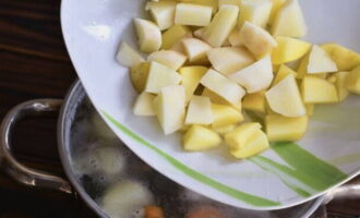 Картофель также нарезаем брусочками и соединяем с бульоном, всыпаем перец душистый горошком, специи для рыбы и оставляем вариться на протяжении 15 минут.
