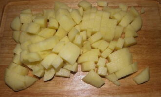 Картофель тщательно вымываем в холодной воде. Нарезаем его на небольшие кубики. Отправляем картофель в бульон. Дождитесь, когда он закипит. Затем добавляем в бульон обжаренные лук и морковь. Тщательно перемешиваем будущую уху. 
