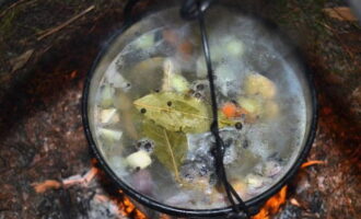 Обратно погружаем в казан рыбу. Добавляем соль, перец и лавровые листочки. Держим над огнем 10 минут.