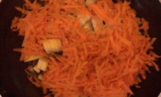Мелко режем лук и высыпаем его на разогретую сковороду с растительным маслом. Постоянно перемешиваем. Обжариваем до золотистого цвета. В процессе обжарки измельчаем морковь (крупно). Добавляем морковь к луку и обжариваем около пяти минут.