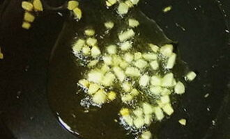 Чеснок очистите и нарежьте небольшими кубиками. На сковороде разогрейте оливковое масло, обжарьте чеснок до легкого золотистого цвета.