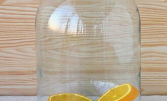 Переложите апельсин в стерилизованную трехлитровую банку.