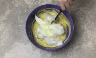 В подошедшую опару добавьте взбитые желтки, оставшийся сахар, соль и размягченное сливочное масло, перемешайте до однородности. Затем выложите белковую массу и перемешайте аккуратными движениями.