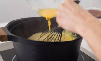 Начинаем мешать суп венчиком, постепенно вливая тонкой струей яйца. На этом этапе добавляем в суп соль с перцем.