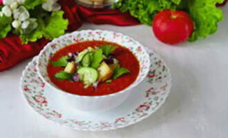 Затем разлейте суп по тарелкам, добавьте дольки огурцов, свежую зелень и гренки.
