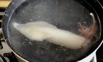 Тушки кальмаров промыть, положить в кипяток со столовой ложкой соли. Варить их нужно буквально минуту, и сразу же достать из воды. 