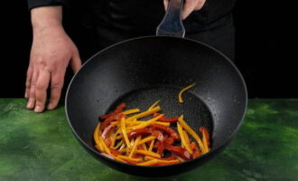 Смазываем сковороду небольшим количеством оливкового масла и обжариваем морковь с перцем на сильном огне примерно минуту.