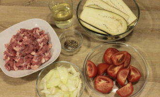 Как приготовить мусаку с баклажанами по-гречески с фаршем по классическому рецепту? Для начала подготавливаем все ингредиенты. Все овощи и мясо тщательно промываем. Баклажаны разрезаем на тонкие пластинки, помидоры режем дольками, а лук соломкой. С баранины снимаем все плёнки, нарезаем на небольшие кусочки и прокручиваем через мясорубку или измельчаем с помощью блендера.