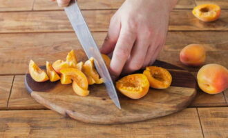 Как испечь вкусную шарлотку с абрикосами в духовке? Абрикосы хорошо промываем, высушиваем и нарезаем сначала половинками, а затем дольками.