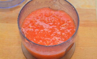Промываем помидоры. Обтираем их кухонным полотенцем. Разрезаем каждый томат вдоль на две половинки (берем только часть плодов, примерно 1,2 кг). Затем выкладываем их в блендер и измельчаем в пюре. Это можно сделать с помощью мясорубки или соковыжималки.