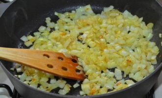 Наливаем оливковое масло в сковороду и распределяем его по дну емкости. Ставим на плиту и включаем технику. Подогреваем сковороду с маслом пару минут. Высыпаем нарезанный лук и обжариваем. 