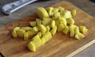 Картофель нарезаем на кубики. В кастрюлю наливаем воду, ставим ее на плиту, кладем туда нарезанный картофель и подсаливаем. 