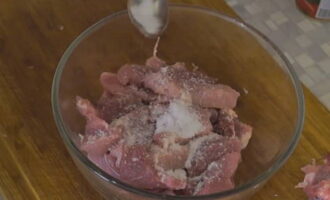 Переложите мясо в глубокую миску, посолите, тщательно перемешайте, чтобы соль распределилась по свинине, и оставьте настаиваться на 5 минут.