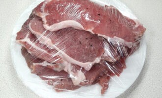 Отбейте мясо, но не до прозрачности, сложите стопкой на тарелку и укройте пищевой пленкой, чтобы оно не заветривалось. Уберите в холодильник.