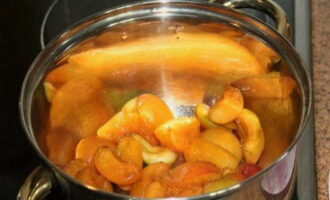Переложите измельчённые фрукты в большую кастрюлю. Туда же влейте воду. Поставьте посуду с фруктами на средний огонь и варите до тех пор, пока они не станут совсем мягкими. После этого слейте воду.