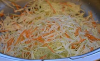 В это время нарезаем капусту тонкой соломкой, а морковь пропускаем через терку. Размешиваем овощи между собой.