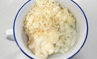 Натрите на крупной терке чуть меньше половины сыра, сложите в глубокую миску вместе с луком и майонезом.