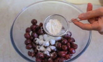 Шумовкой извлекаем горячие ягоды из кастрюли и перекладываем их в небольшую тарелку. Посыпаем вишню крахмалом.