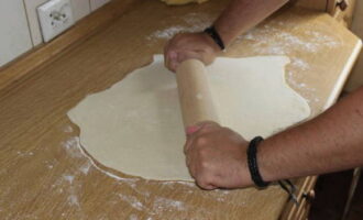 Плотное тесто раскатываем в тонкий слой.