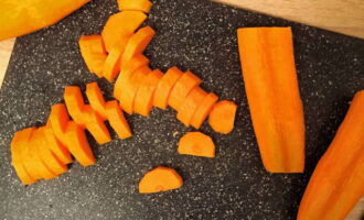 Срезаем небольшой слой моркови, очищаем ее при помощи щетки или губки. Нарезаем овощ полукольцами.