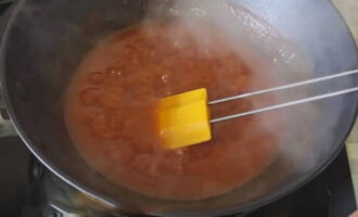 На небольшом огне кипятите томатную смесь в течении нескольких минут, затем влейте уксусную эссенцию, перемешайте и оставьте кипеть еще на 5 минут. Влейте разведенный крахмал и пару столовых ложек растительного масла, перемешайте и продолжайте варить соус до загустения.