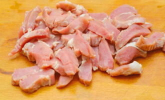 Свиное мясо промываем и промакиваем бумажным полотенцем. Нарезаем мясо кусочками и солим. Форму для выпечки смазываем растительным маслом. Выкладываем свинину на дно формы, поверх нее – овощное рагу. 