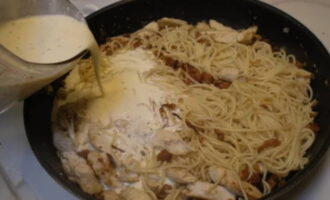 Кладём на сковородку уже готовые спагетти. Заливаем их соусом. Огонь стоит уменьшить, чтобы спагетти не подгорели. Их необходимо перемешать деревянной или силиконовой лопаткой и дать потушиться на протяжении 5 минут. В результате соус должен немного загустеть. 
