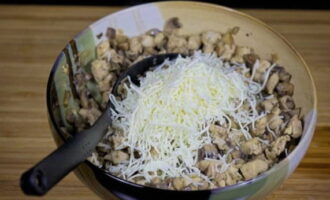 Остаток тертого сыра добавляем к курице с грибами.