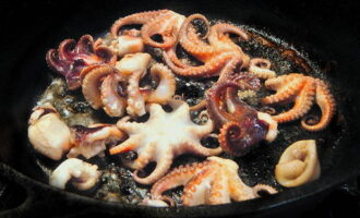 В чесночном масле обжарить морепродукты на среднем огне 5 минут. 