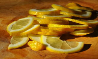 Апельсины и лимоны хорошенько вымыть и нарезать полукольцами. Не стоит делать слишком тонкие ломтики, чтобы они также сохраняли форму в банке. 