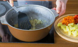 В казан влейте растительное масло, сначала обжарьте лук до мягкости.