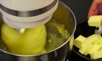 Далее добавьте в тесто размягченное сливочное масло, продолжайте вымешивать тесто до однородности.