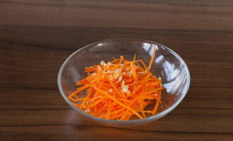 Морковь помойте, очистите и натрите соломкой. Чеснок очистите от шелухи, измельчите его и смешайте с морковкой.