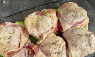 Куриные бедра помойте, натрите солью и специями. Положите мясо на овощи.