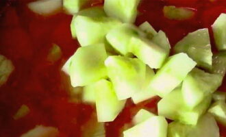 Выложите огурцы в томатную заливку, доведите до кипения и продолжайте варить еще 5 минут.