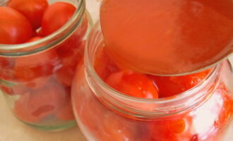 Заливаем помидоры проваренным томатным соком с сахаром, солью и уксусом. Закатываем продукт и оставляем до полного остывания в теплом месте.