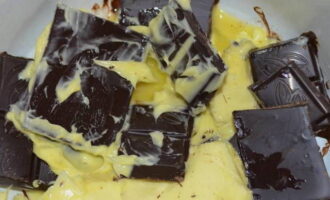 Кусочки темного шоколада кладем в кастрюлю вместе со сливочным маслом. Растапливаем продукты на водяной бане.