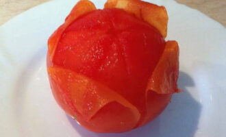 Перед тем, как нарезать мякоть помидоров, следует сначала избавить томаты от шкурки. Заливаем помидоры кипятком, предварительно надрезав верхушки (надрез должен быть в форме креста). Через 1-2 минуты воду следует вылить и заменить ее холодной. 