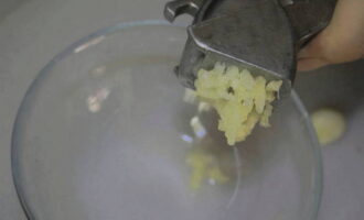 Головку чеснока избавляем от шелухи. Измельчаем чеснок способом, который больше подходит: ножом или с помощью чесночницы. Выкладываем его к овощам в кастрюле и перемешиваем. Оставляем на 5 минут.