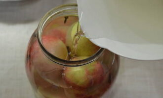 Когда сахар с солью растворятся, заливаем яблоки в банке рассолом.