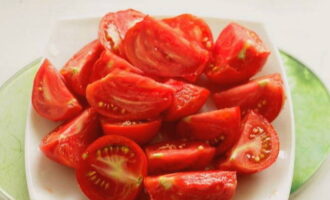 У помидоров вырезаем плодоножку и нарезаем ломтиками такого размера, чтобы они не потеряли форму в салате. 