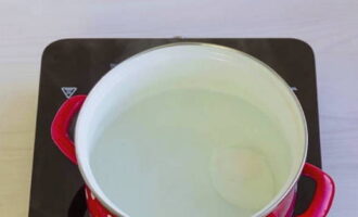 В кастрюле вскипятите воду, добавьте пару щепоток соли, затем убавьте огонь. Для приготовления яиц достаточно, чтобы температура воды была 70-80 градусов. Поднесите миску с яйцом максимально близко к поверхности воды и опрокиньте ее в воду.