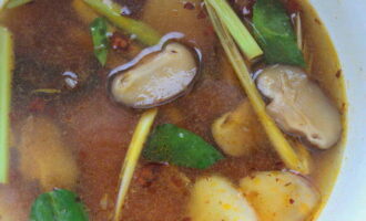 Далее добавьте тайский соус, нарезанные грибы и варите еще 2 минуты.
