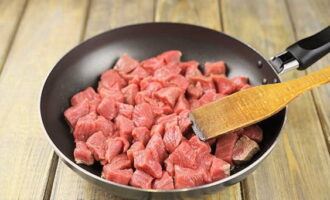 Как приготовить тушеную говядину с подливкой на сковороде? Говядину промываем и обсушиваем, после чего режем ее некрупными кусочками. Разогреваем масло на сковороде и выгружаем на нее мясо.